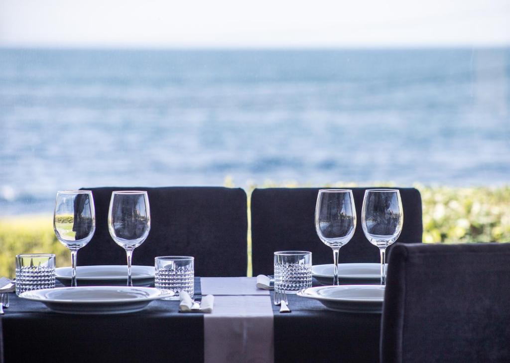 una mesa con cuatro copas de vino y platos en ella en Casa da Vasca, en Malpica de Bergantiños