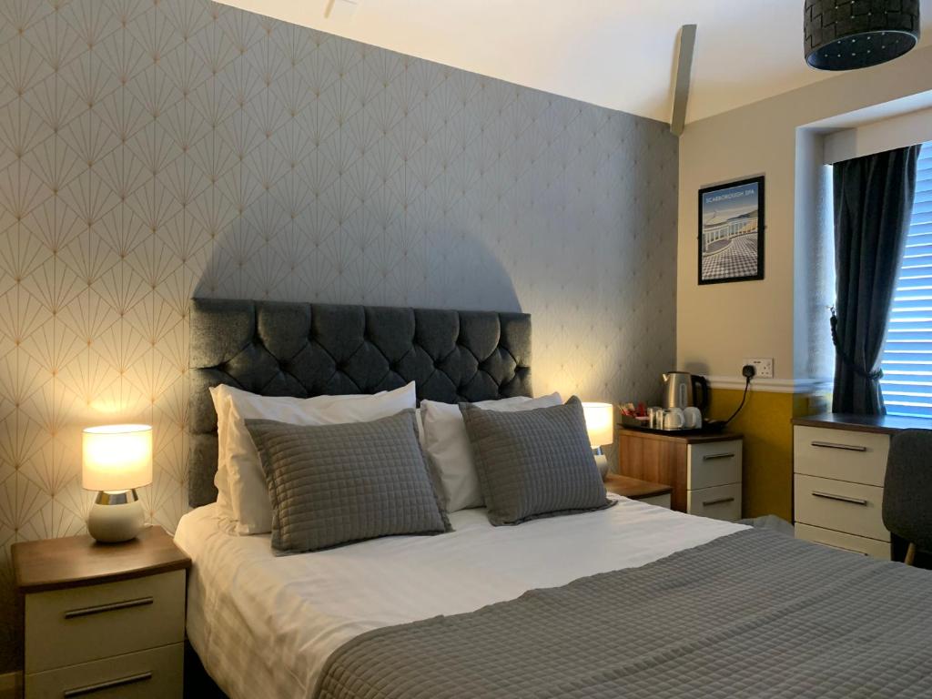 um quarto com uma cama grande e uma cabeceira. em The Headlands Hotel em Scarborough