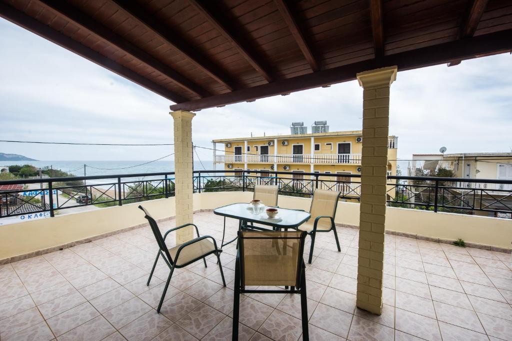 a patio with a table and chairs on a balcony at Pantelis Apartments in Agios Georgios