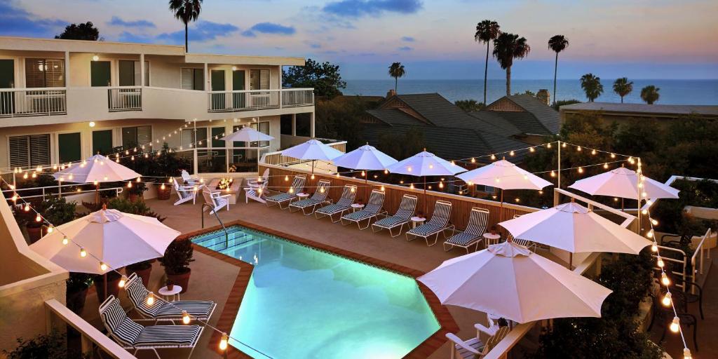 a hotel with a pool and chairs and umbrellas at Laguna Beach House in Laguna Beach