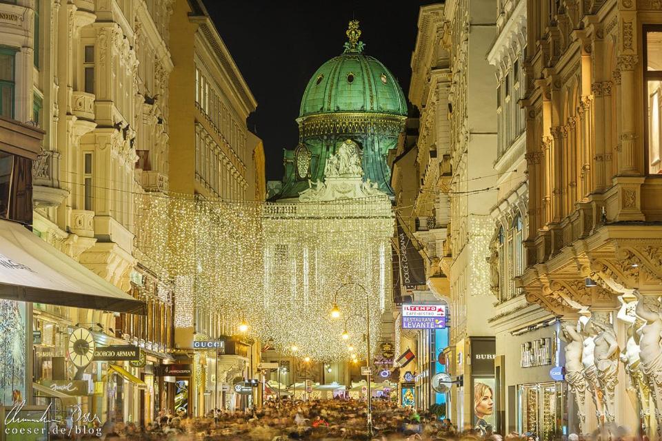 a crowd of people walking down a street at night at Kaiserin Sissi - City Apartment Downtown Vienna in Vienna