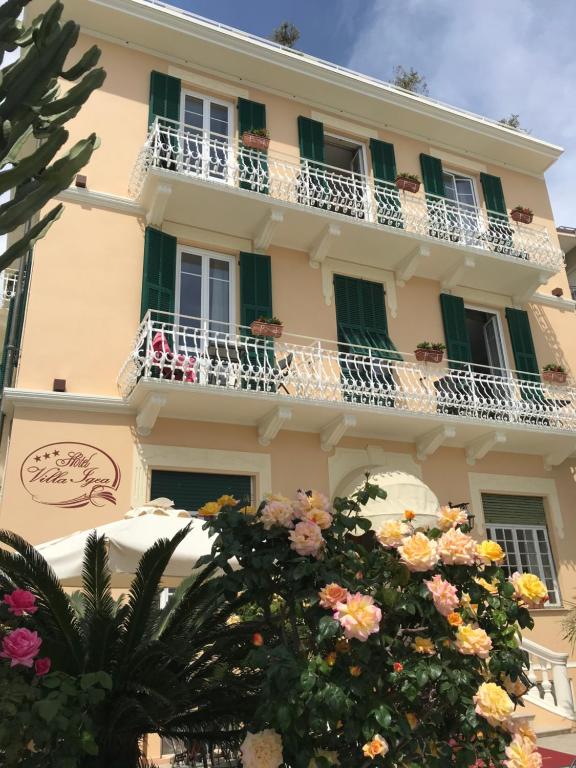 un edificio con balcones y flores delante de él en Hotel Villa Igea, en Alassio