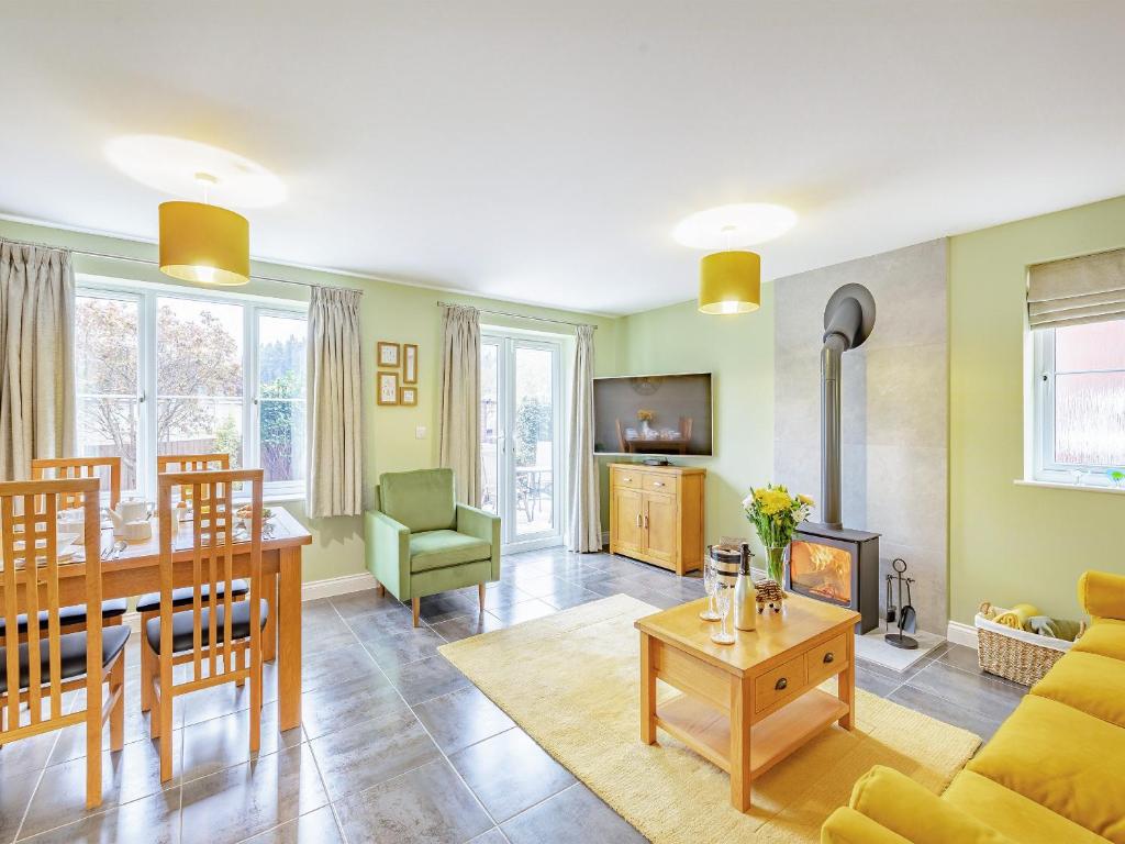 a living room with a table and a dining room at Humbug House in Lower Soudley