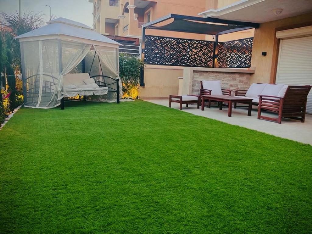 a backyard with a gazebo and green grass at شقه فندقية بالشيخ زايد in Sheikh Zayed