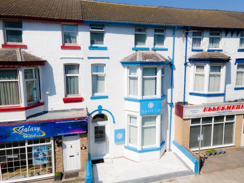 a large white building with blue trim and windows at The New Apollo Hotel in Blackpool