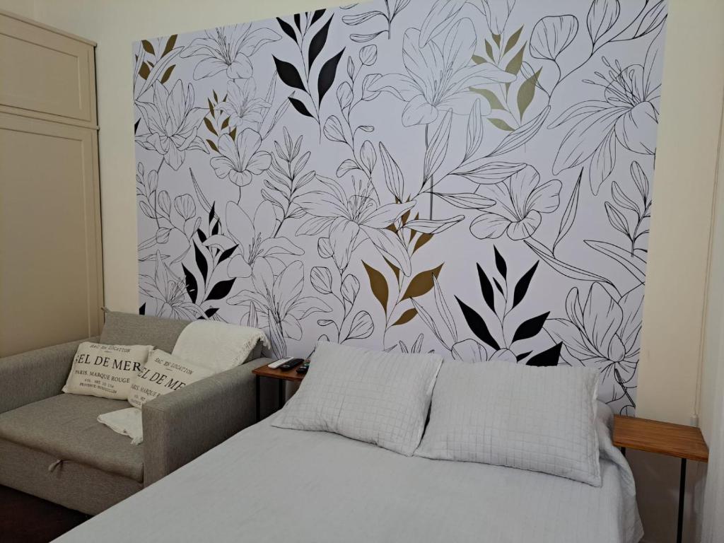 1 dormitorio con 1 cama y una pared con un mural de flores en HOME - Excelente ubicación en Buenos Aires