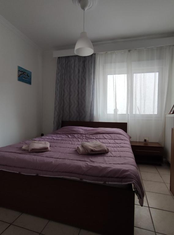 - une chambre avec un lit violet et 2 serviettes dans l'établissement Helena's Apartment 2 Agia Triada, à Thessalonique