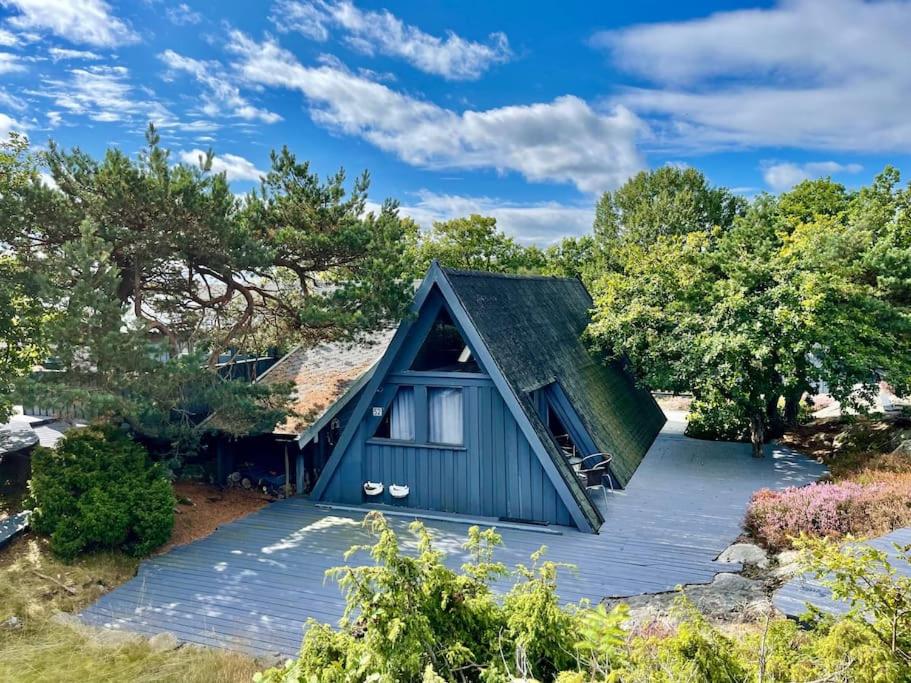a small blue house with a pitched roof at Fantastic Sea Cottage on Justøya Island, Lillesand in Lillesand