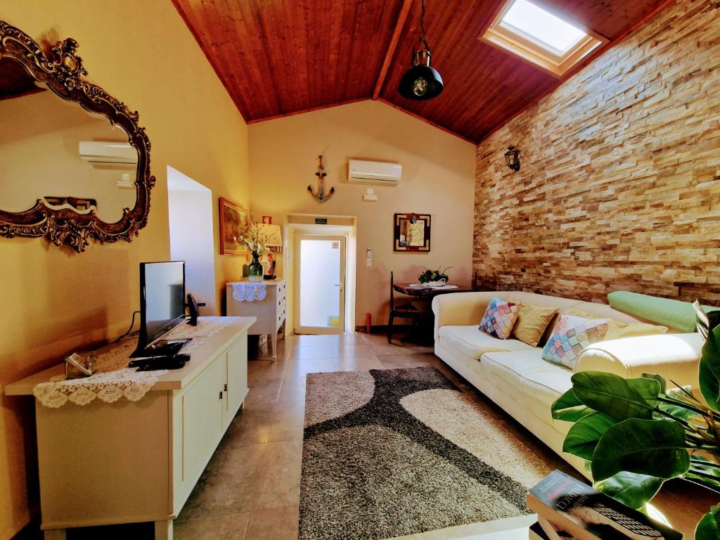 a living room with a couch and a brick wall at Casa das Azenhas by Lisbon Village Apartments in Sintra
