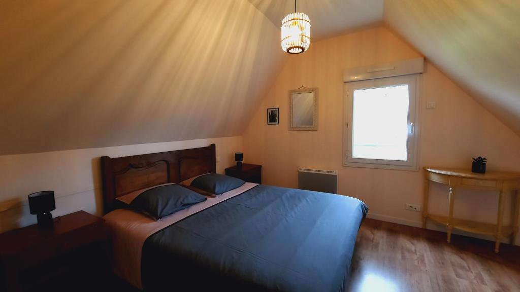 - une chambre avec un lit bleu et une fenêtre dans l'établissement Maison La Denolais Carnet Mont-Saint-Michel, à Saint-James