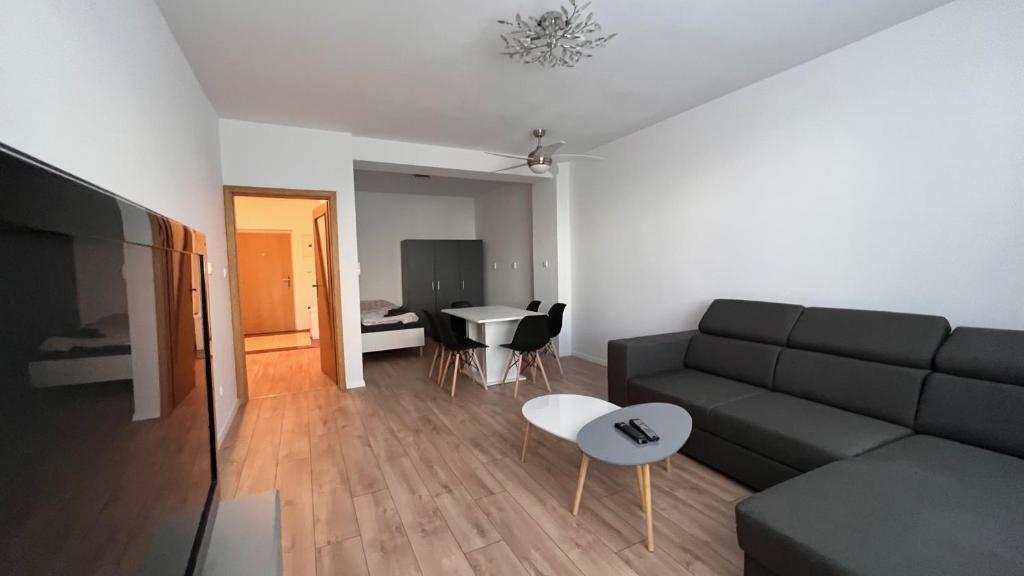 uma sala de estar com um sofá e uma mesa em 2 room apartment, near OC Galeria, Petržalka em Bratislava