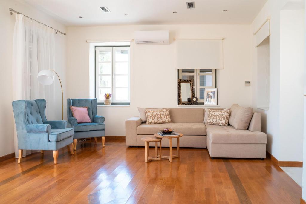 sala de estar con sofá y 2 sillas azules en Naias Aegina, Sea-front apartment 95 sqm, en Aegina Town