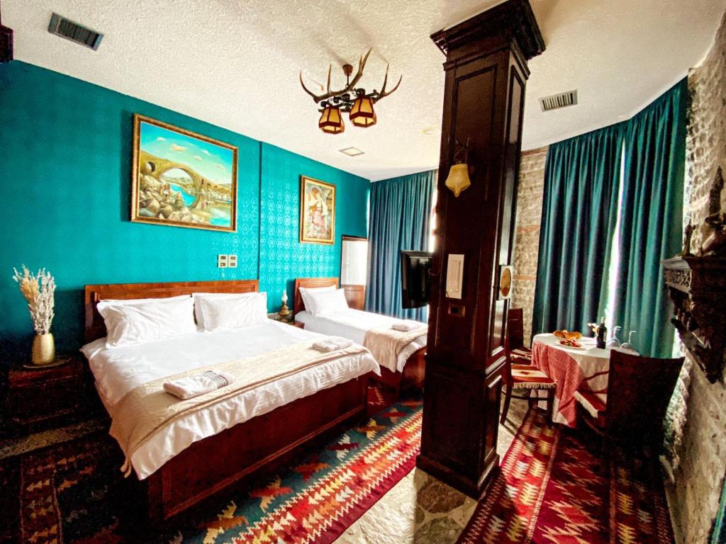 a hotel room with two beds and blue walls at Hotel Iliria in Shkodër