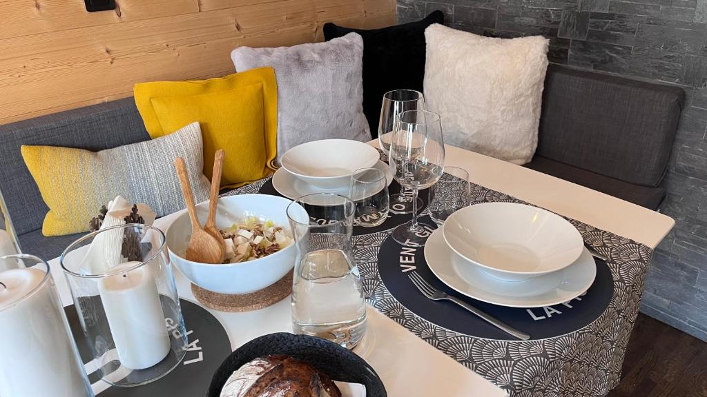 een tafel met borden en kommen met eten erop bij Appartement type studio dans Chamonix Centre in Chamonix-Mont-Blanc