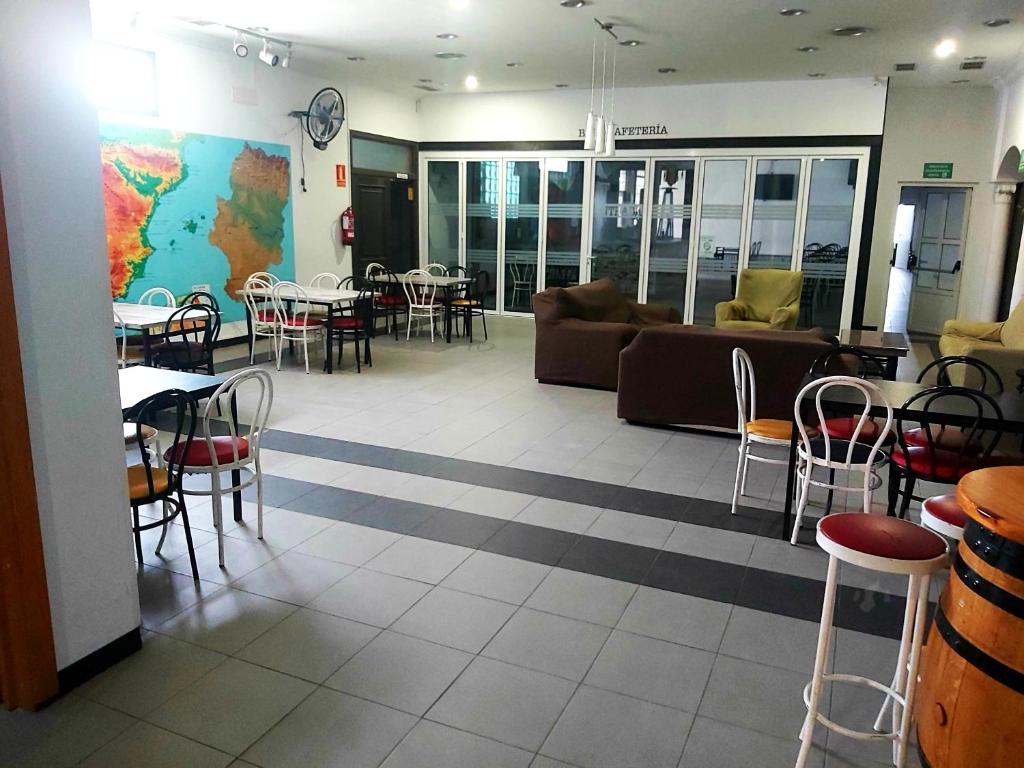 a lobby with tables and chairs and a couch at Albergue Internacional de Teruel City Backpackers in Teruel