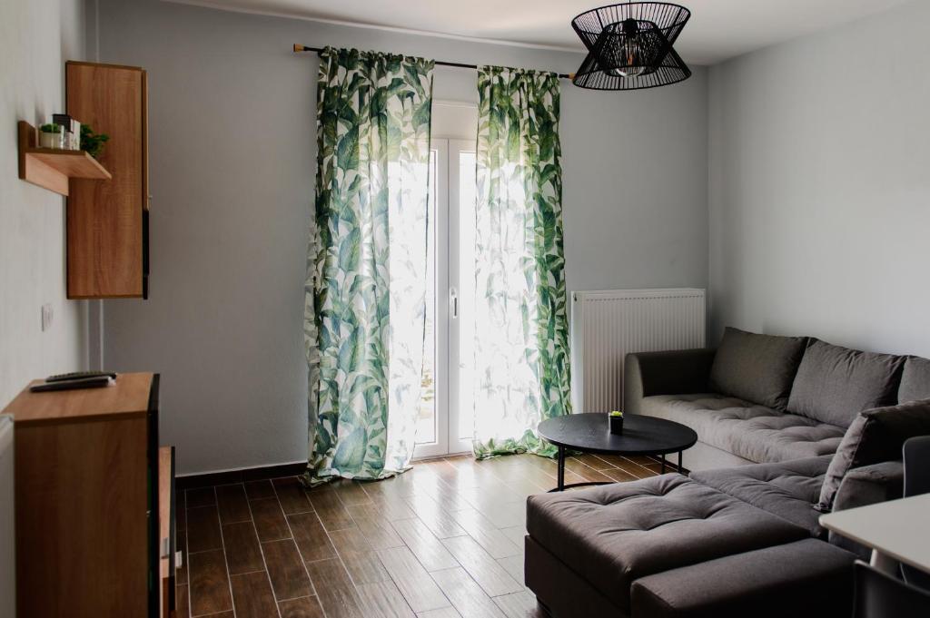 a living room with a couch and a large window at Ολόκληρο Διαμέρισμα η Βυσσινιά in Kotrónion