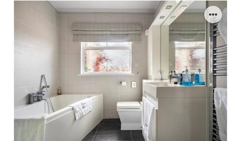 ein weißes Badezimmer mit einer Badewanne und einem Waschbecken in der Unterkunft Cullentra House in Cushendall