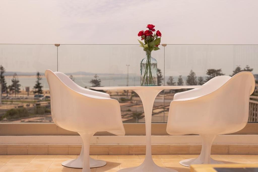 dos sillas blancas y una mesa con un jarrón de flores en Dar YAMAR en Esauira