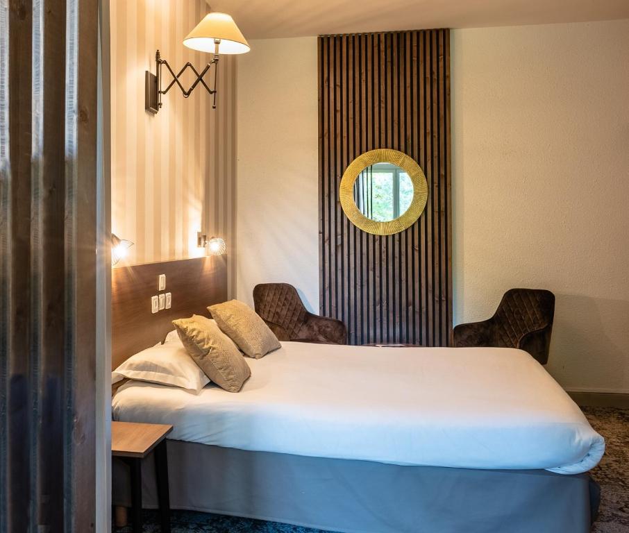 um quarto de hotel com uma cama e um espelho em Relais Amadourien em Rocamadour