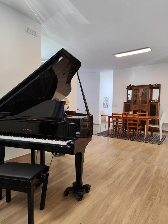a piano in a room with a table and chairs at Iris Casa Vacanza in Noci