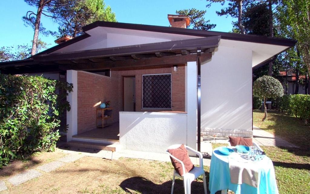 a small white shed with a table in the yard at Villa Capinera in Lignano Sabbiadoro