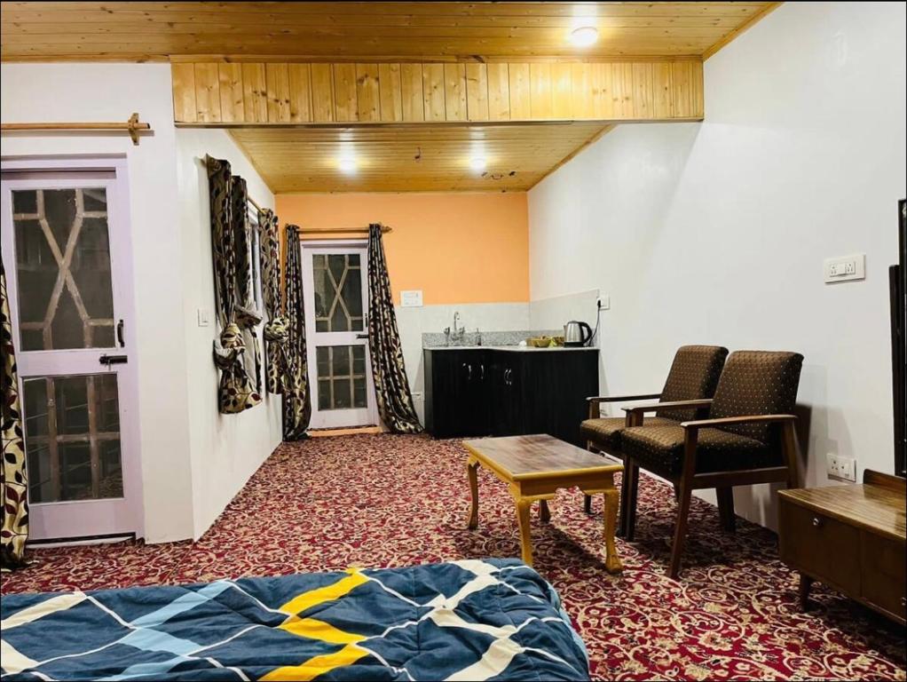 Habitación con cama, mesa y sillas. en Ashai Villa Studio Apartment in Srinagar, en Srinagar
