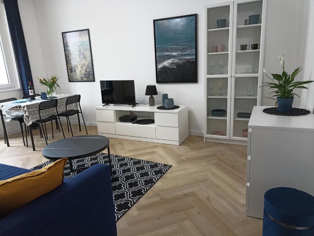 een woonkamer met een bank, een tv en een tafel bij Zaciszny Apartament Old Town Gdansk in Gdańsk