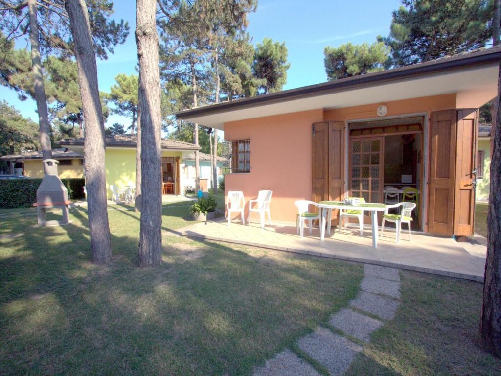 een huis met een patio met een tafel en stoelen bij Borgo Veneziano in Lignano Sabbiadoro