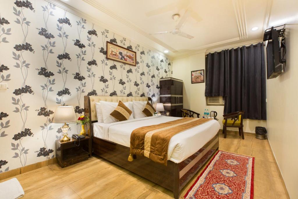 a bedroom with a king sized bed with floral wallpaper at The Alpino Hotel in New Delhi