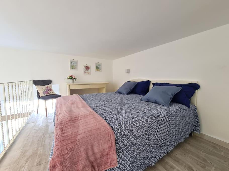 a bedroom with a bed with blue pillows and a desk at Casetta Mirella in Capri