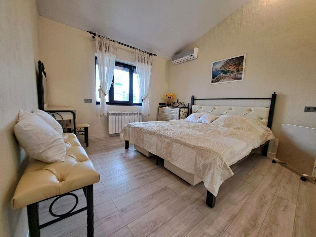 a bedroom with a large bed and a chair at Пентхаус с террасой. Апартаменты в центре in Kharkiv