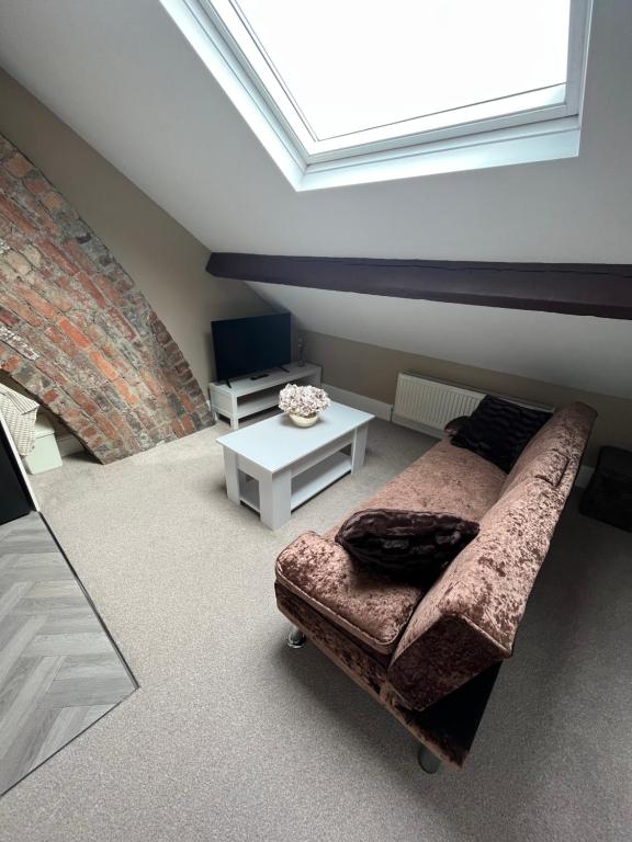 a living room with a couch and a table at Modern En-Suite Rooms Town Centre Self-Check In in Barnsley