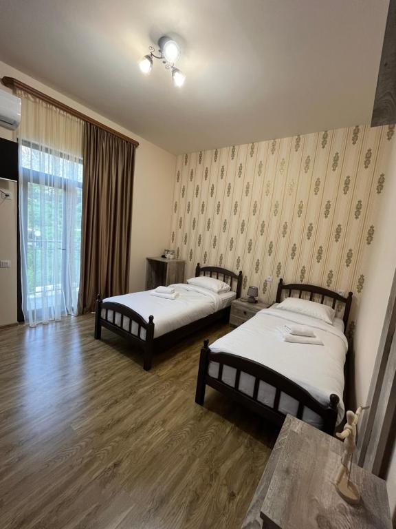 Duas camas num quarto com pisos em madeira em NAREMA FAMILY HOTEL MEGHRI em Meghri