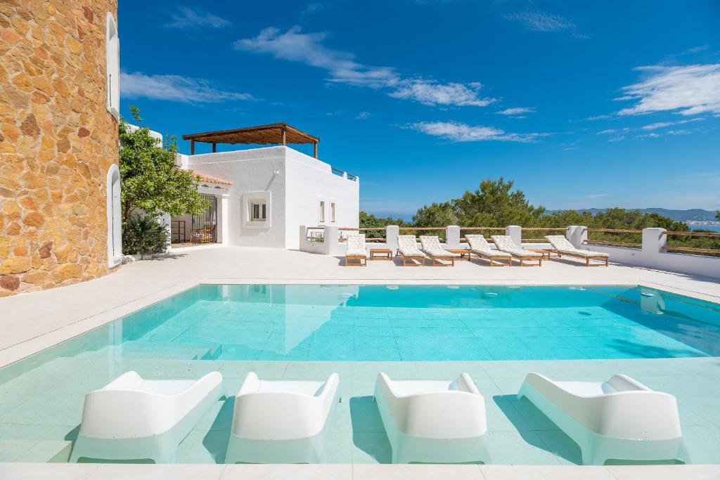 una villa con piscina e sedie a sdraio di Villa Horizonte - Eivillas Ibiza a Port des Torrent