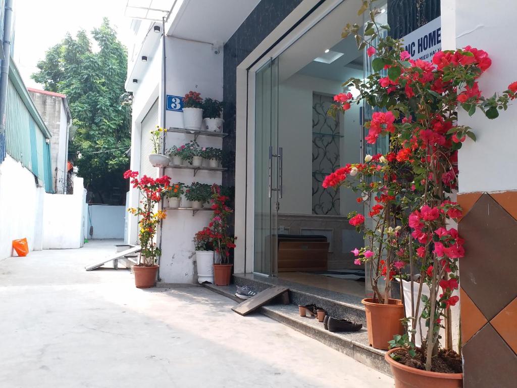 Una puerta a un edificio con flores. en BBNC Homestay, en Hoàng Mai