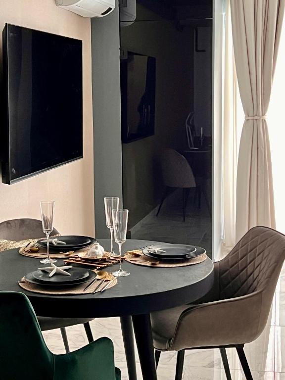 a dining room table with plates and wine glasses at Blue Luxury Studio in Mamaia