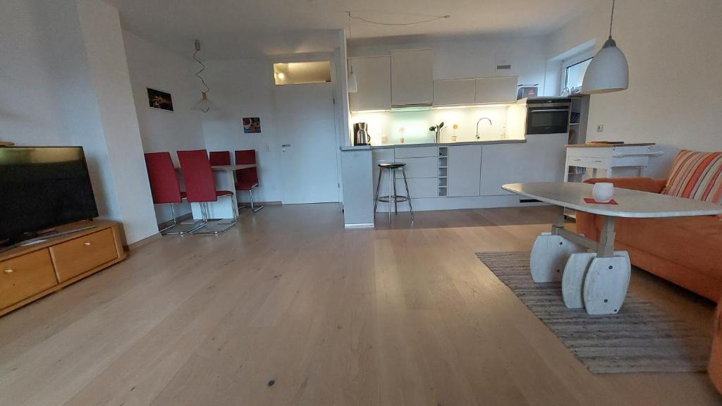 ein Wohnzimmer mit einem Sofa und einem Tisch sowie eine Küche in der Unterkunft Ferienwohnung sunset Weissenstadt in Weißenstadt