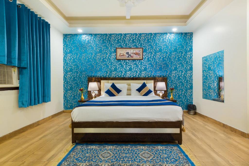 - une chambre bleue avec un lit et un mur bleu dans l'établissement OPO The Alpino, Delhi Airport, à New Delhi