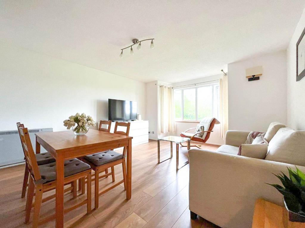 uma sala de estar com uma mesa e um sofá em Lovely 2 bedroom flat with free parking, great transport links to Central London, the Excel Centre, Canary Wharf and the O2! em Londres