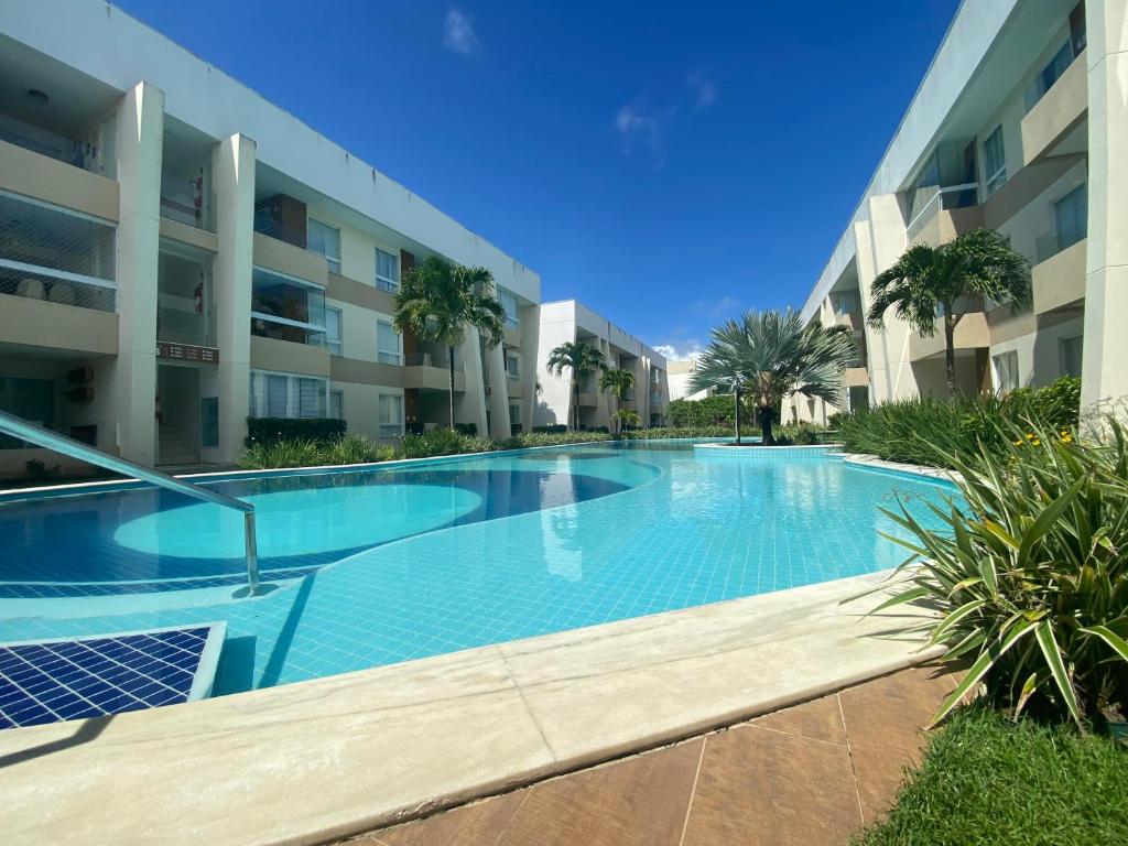 a swimming pool in front of a building at Flat Guarajuba, Charmoso Porto Smeralda in Guarajuba