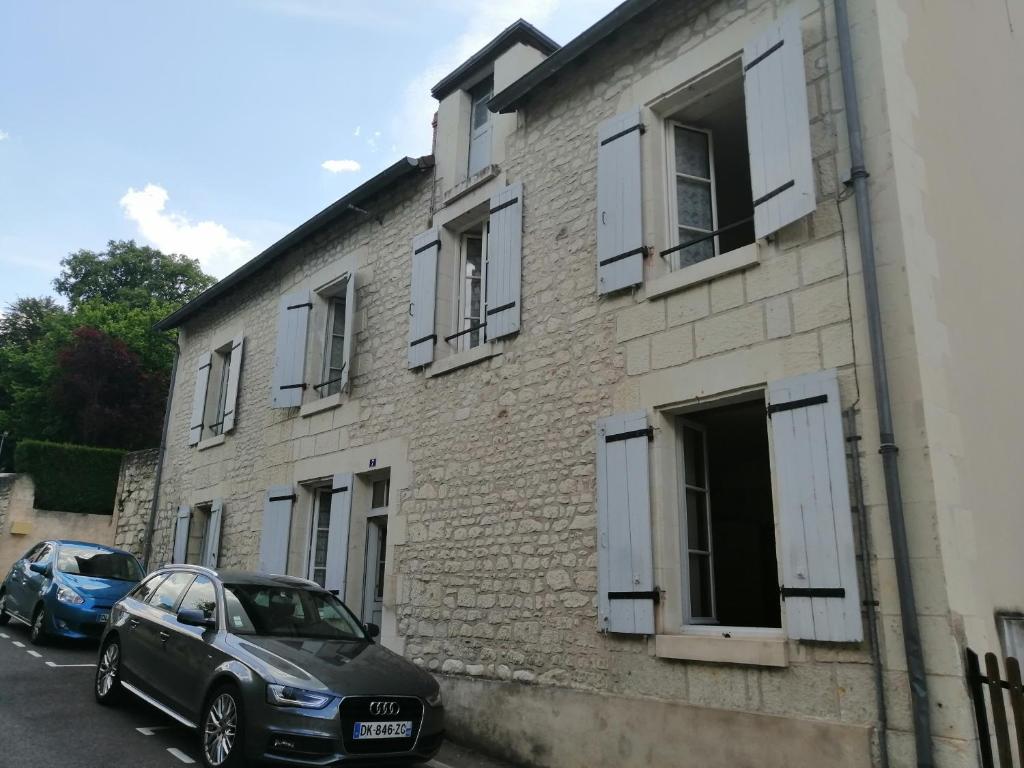 a car parked in front of a brick building at Aux plumes in La Roche-Posay