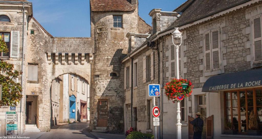 a street with stone buildings and a sign on a pole at L&#39;idéale in La Roche-Posay