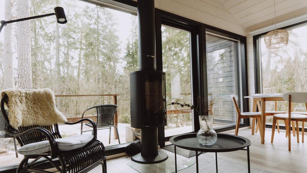 a living room with a wood stove and a table and chairs at Tammikon Tupa in Tuusula