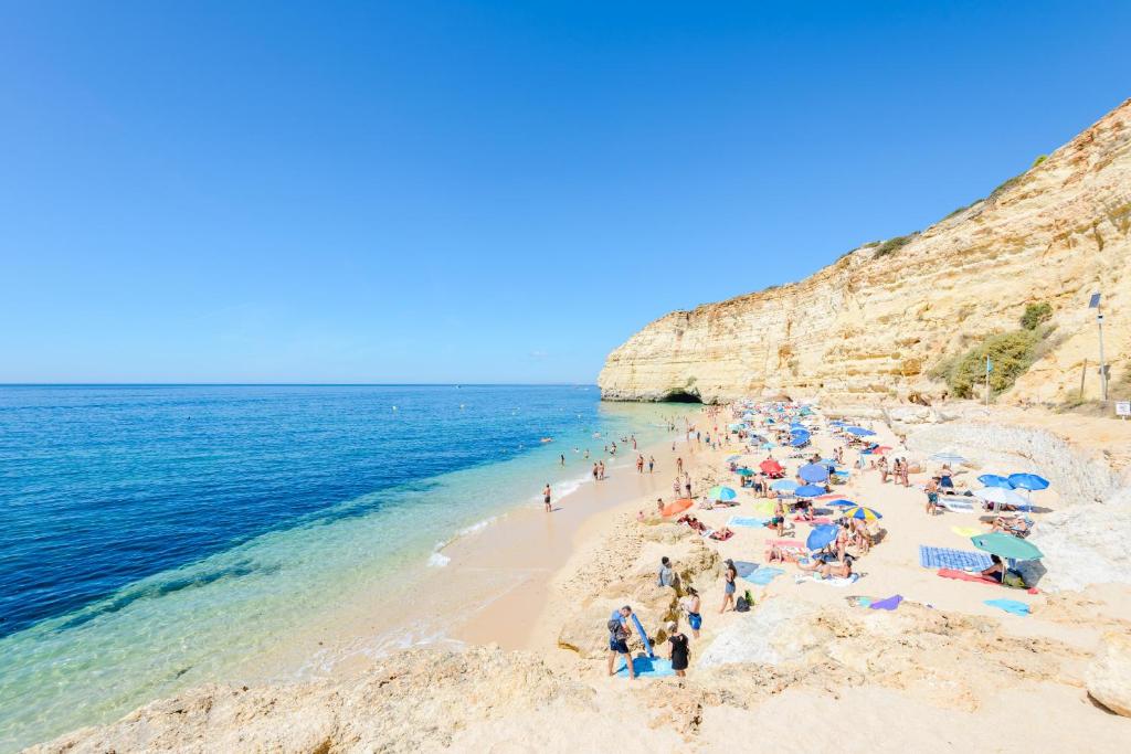 een groep mensen op een strand bij de oceaan bij Apartment Colina Sol in Carvoeiro