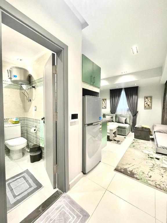 a kitchen with a refrigerator and a living room at Luxury Studio House 589-3 in 6th Of October