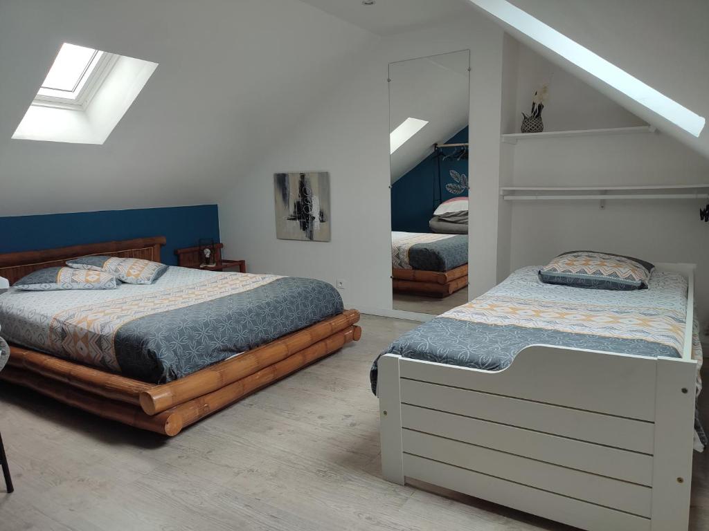 a bedroom with two twin beds and a attic at Claude et Astrid in Tour-en-Bessin