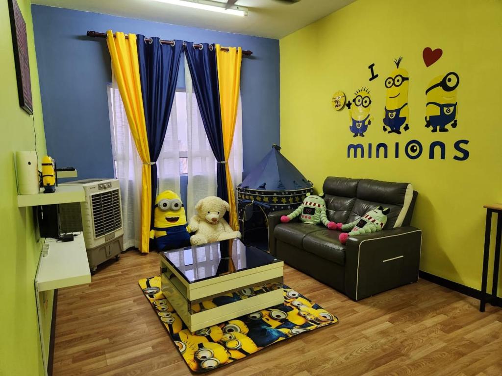 Una habitación infantil con una habitación con un sofá y una habitación con un cartel de Minions. en Triple H Minionstay Kuala Terengganu, en Kuala Terengganu