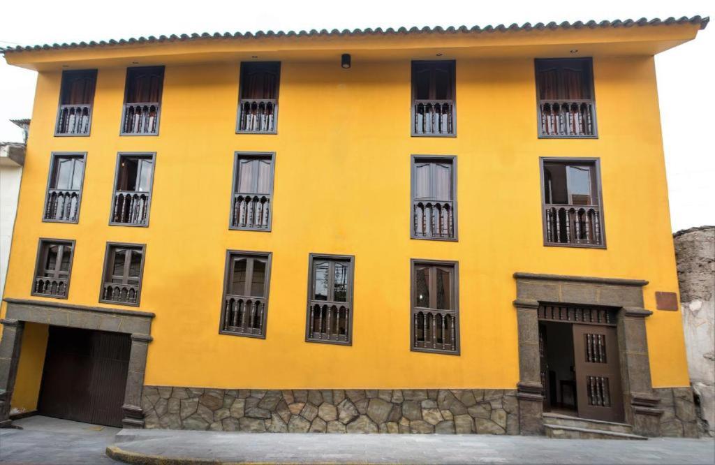 THIZMA HOTELES Ex HotelSantaMaria في اياكوتشو: مبنى اصفر نوافذه جانبيه