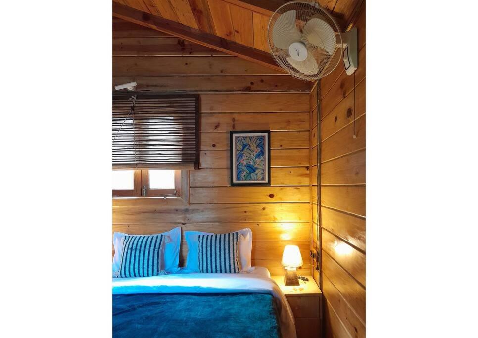 ビムタルにあるWhistling Thrush Chaletの木製の壁のベッドルーム1室