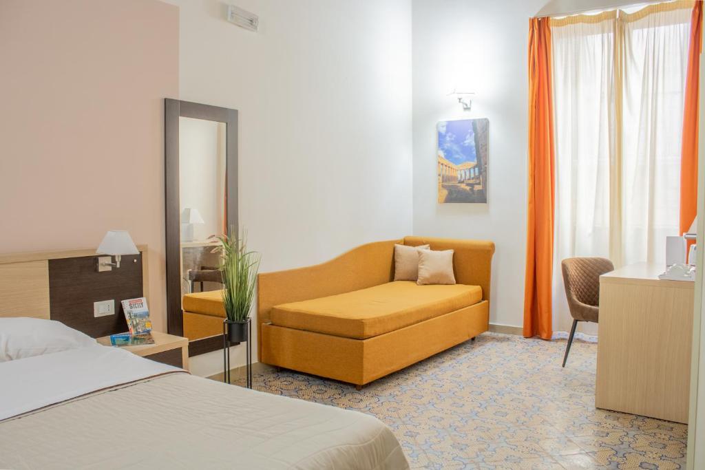 una camera d'albergo con letto e sedia gialla di Porta delle Botteghelle a Trapani